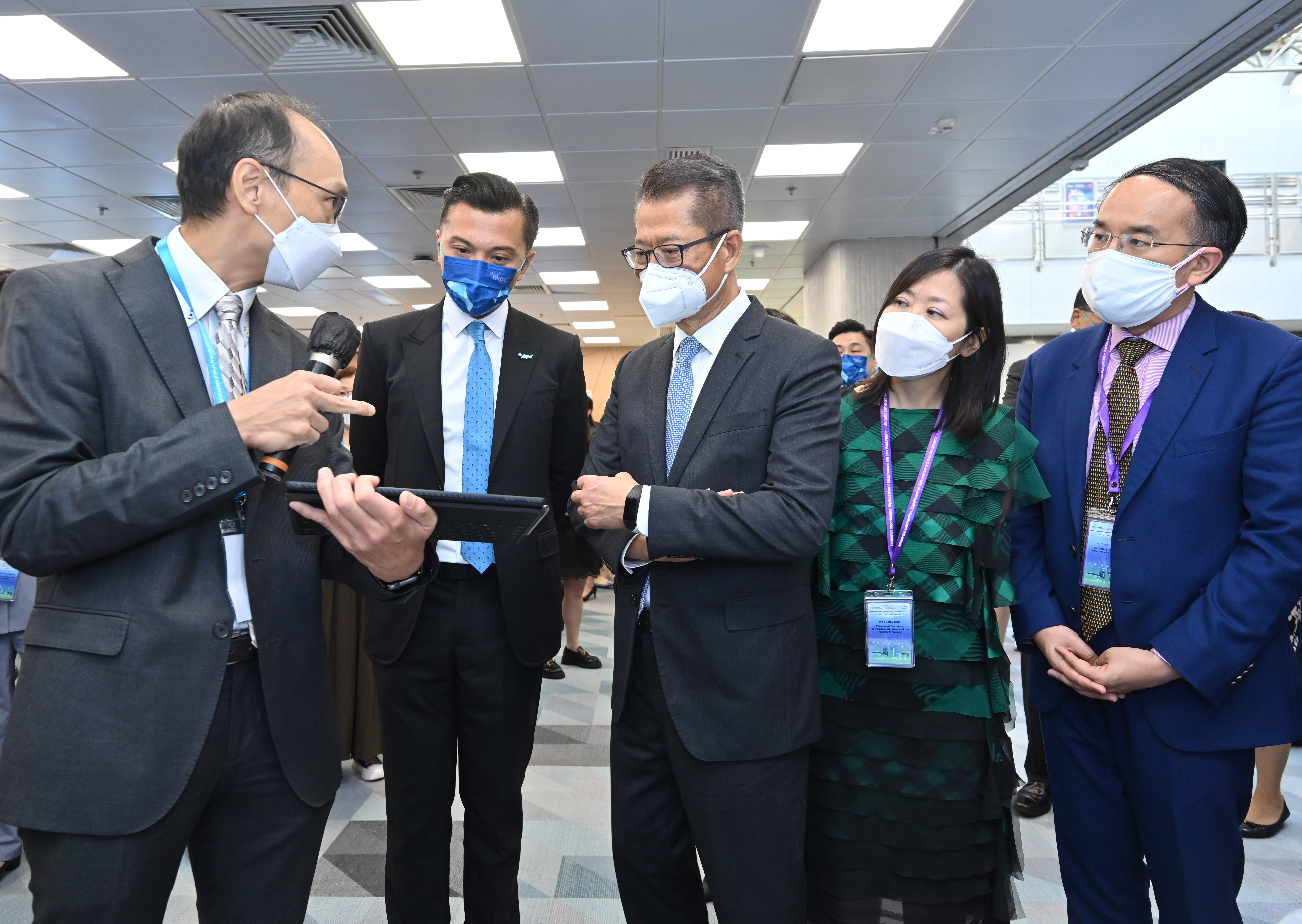 Photo of Mr Paul Chan, Mr Christopher Hui and Miss Cathy Chu with one of the exhibitors