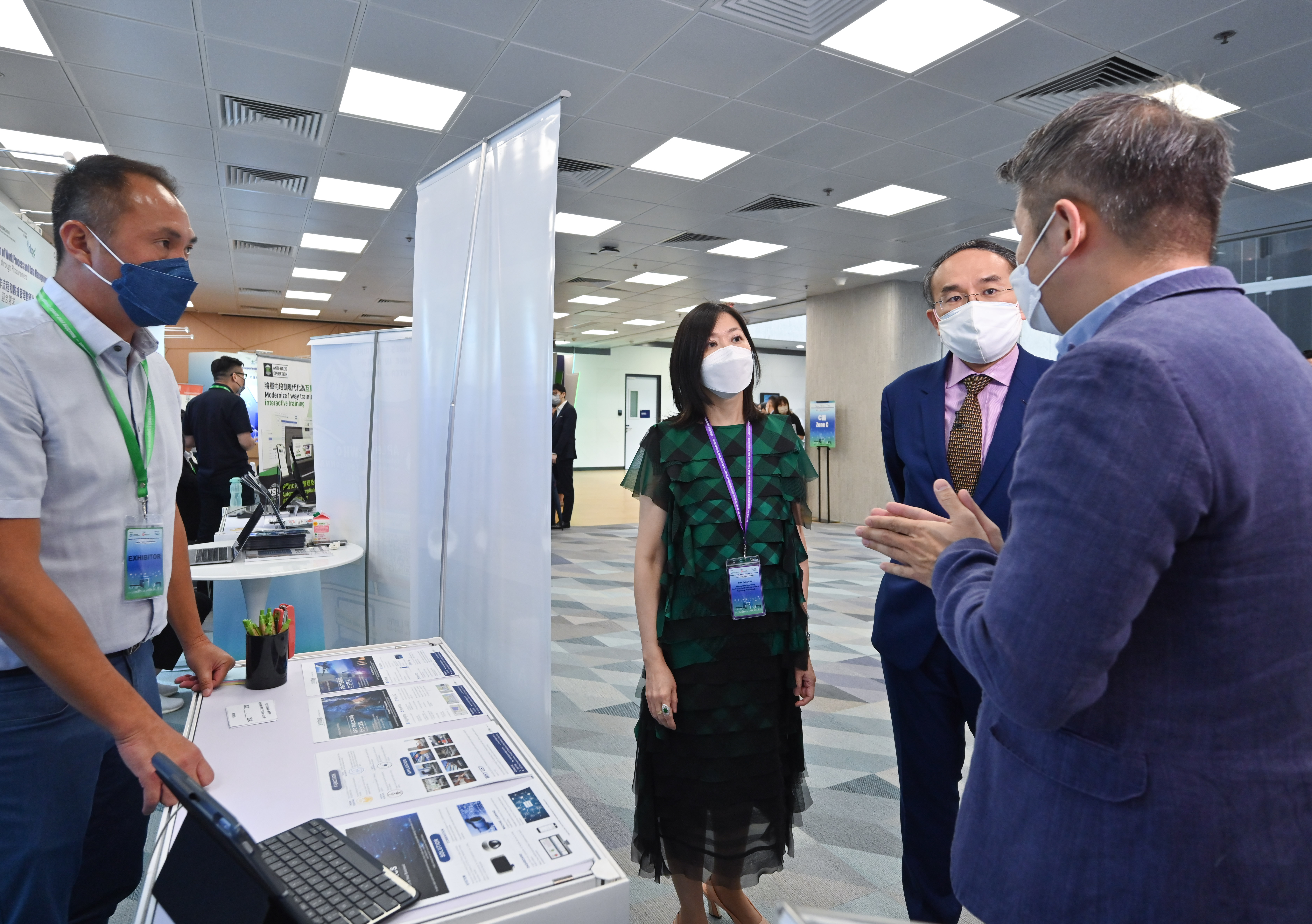Photo of Mr Christopher Hui and Miss Cathy Chu exchanging views with an exhibitor